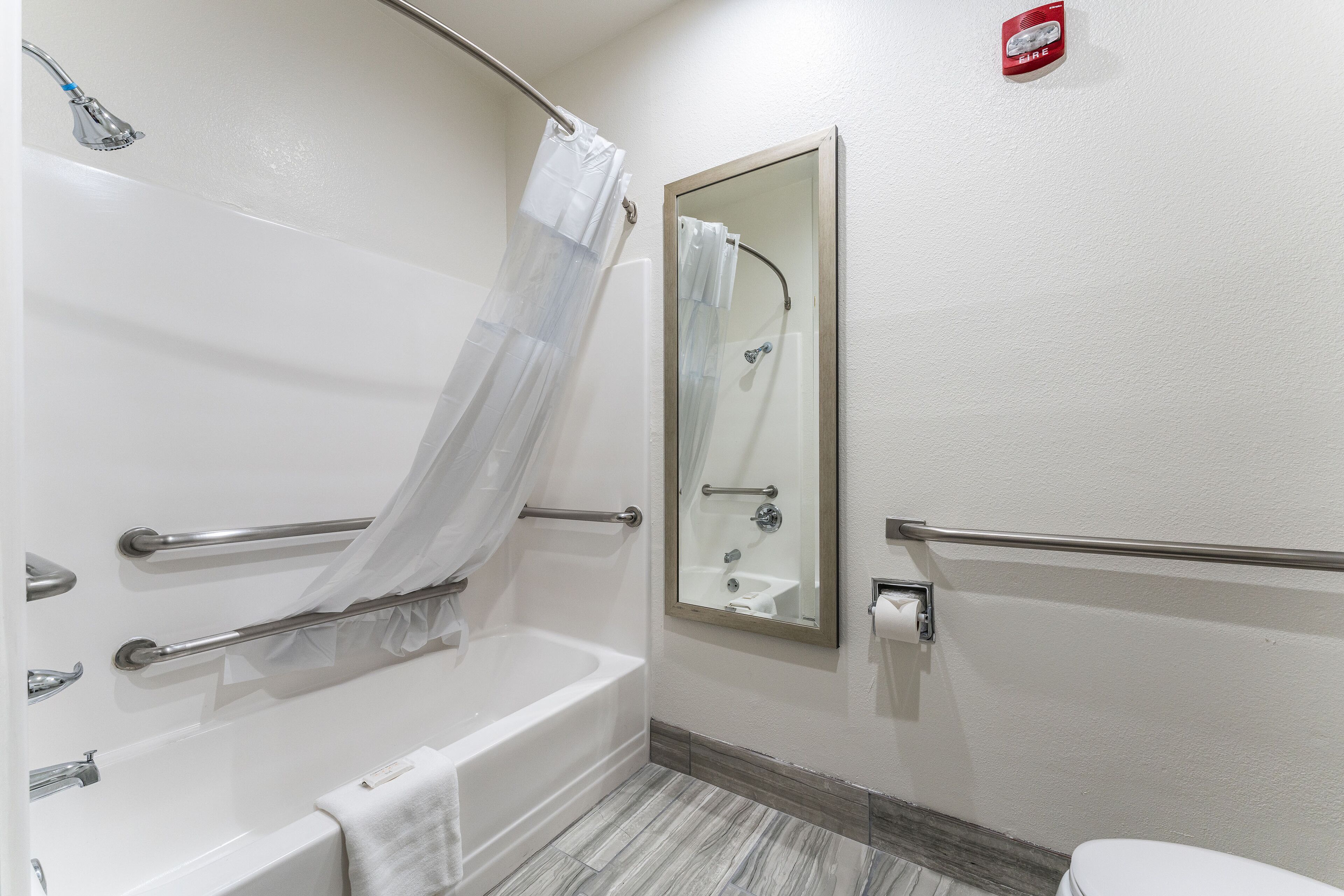 Un baño con bañera, inodoro, ducha y espejo.