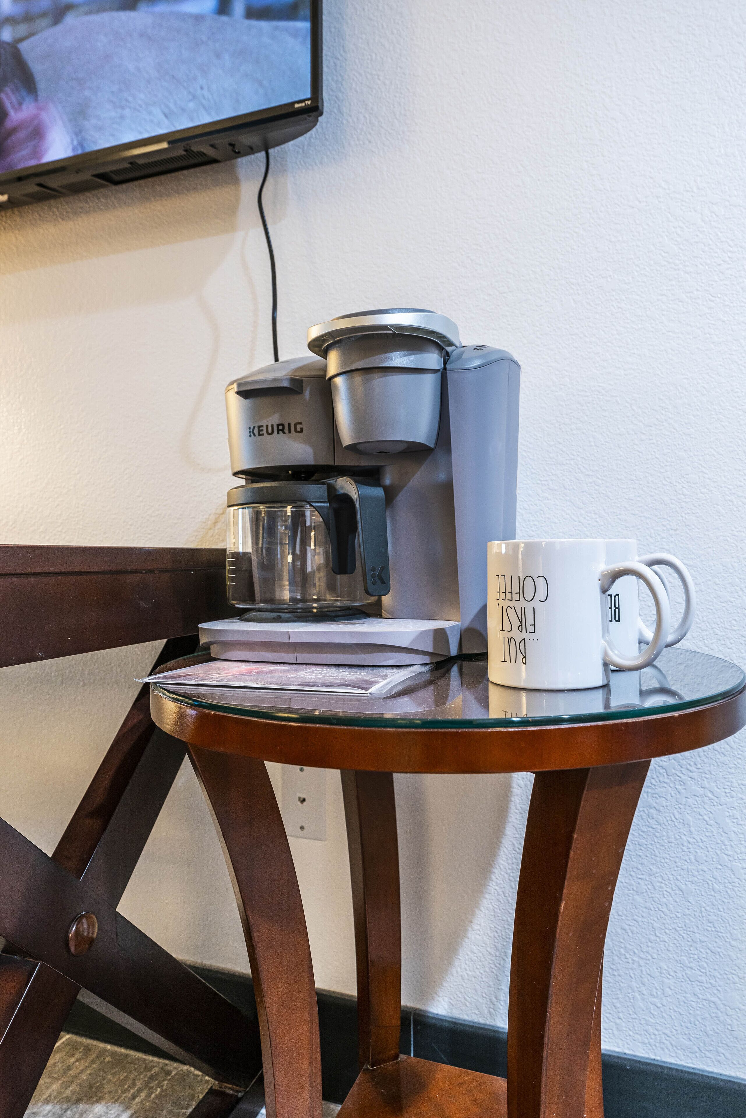 En kaffebryggare står på ett bord tillsammans med en mugg.