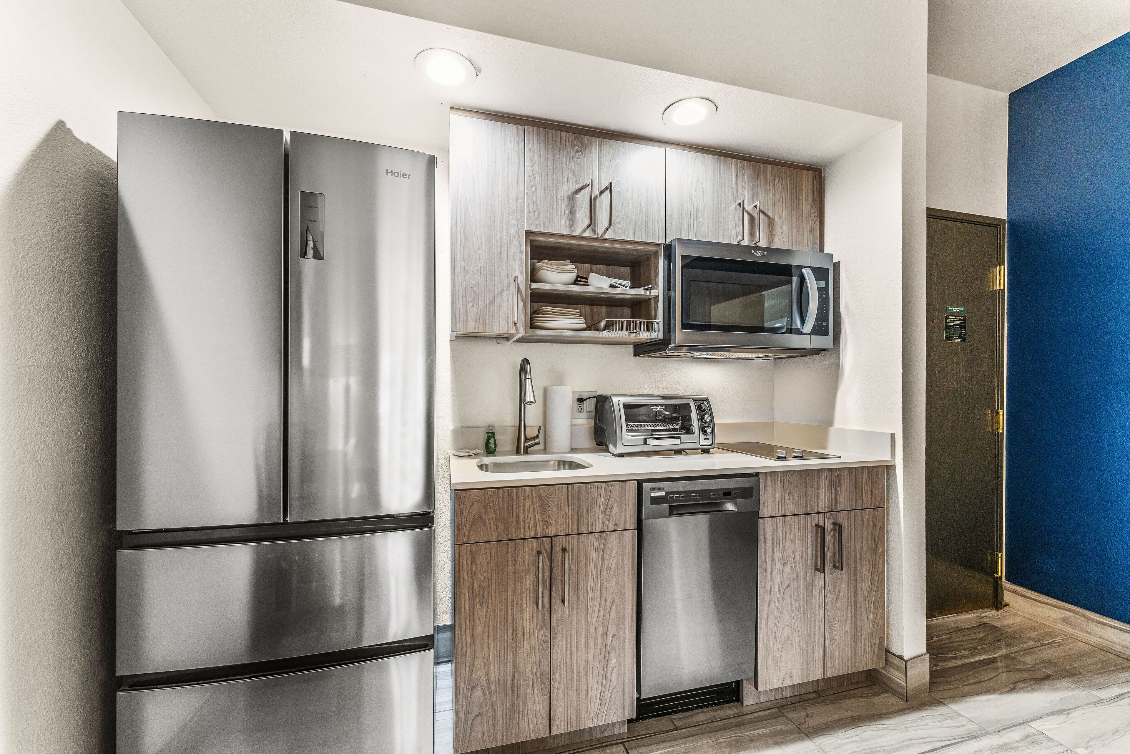 Una cocina moderna con electrodomésticos de acero inoxidable, armarios de madera y un microondas integrado.