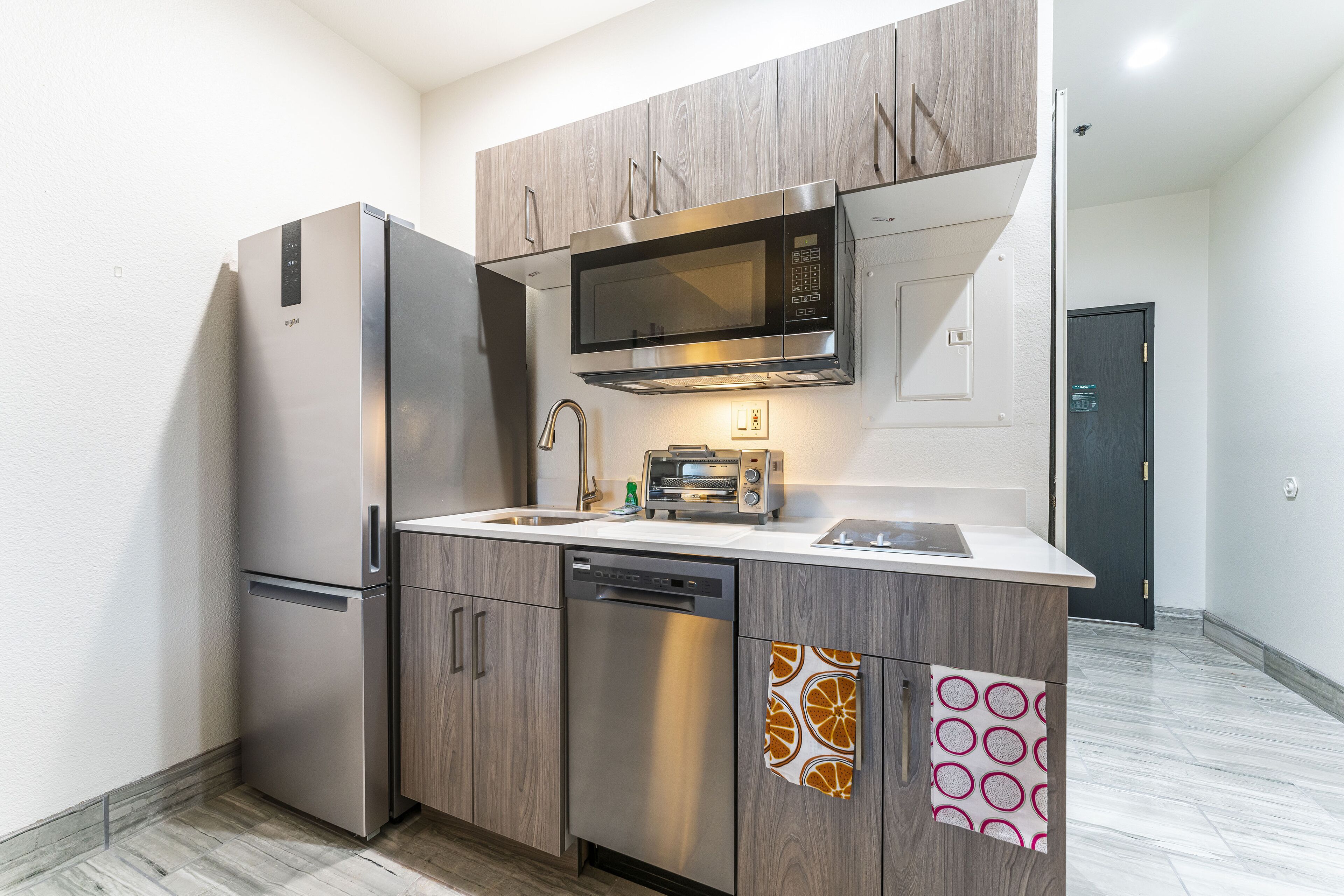 A modern kitchen with stainless steel appliances, a dishwasher, and a microwave.