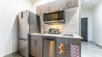 A modern kitchen with stainless steel appliances, a dishwasher, and a microwave.