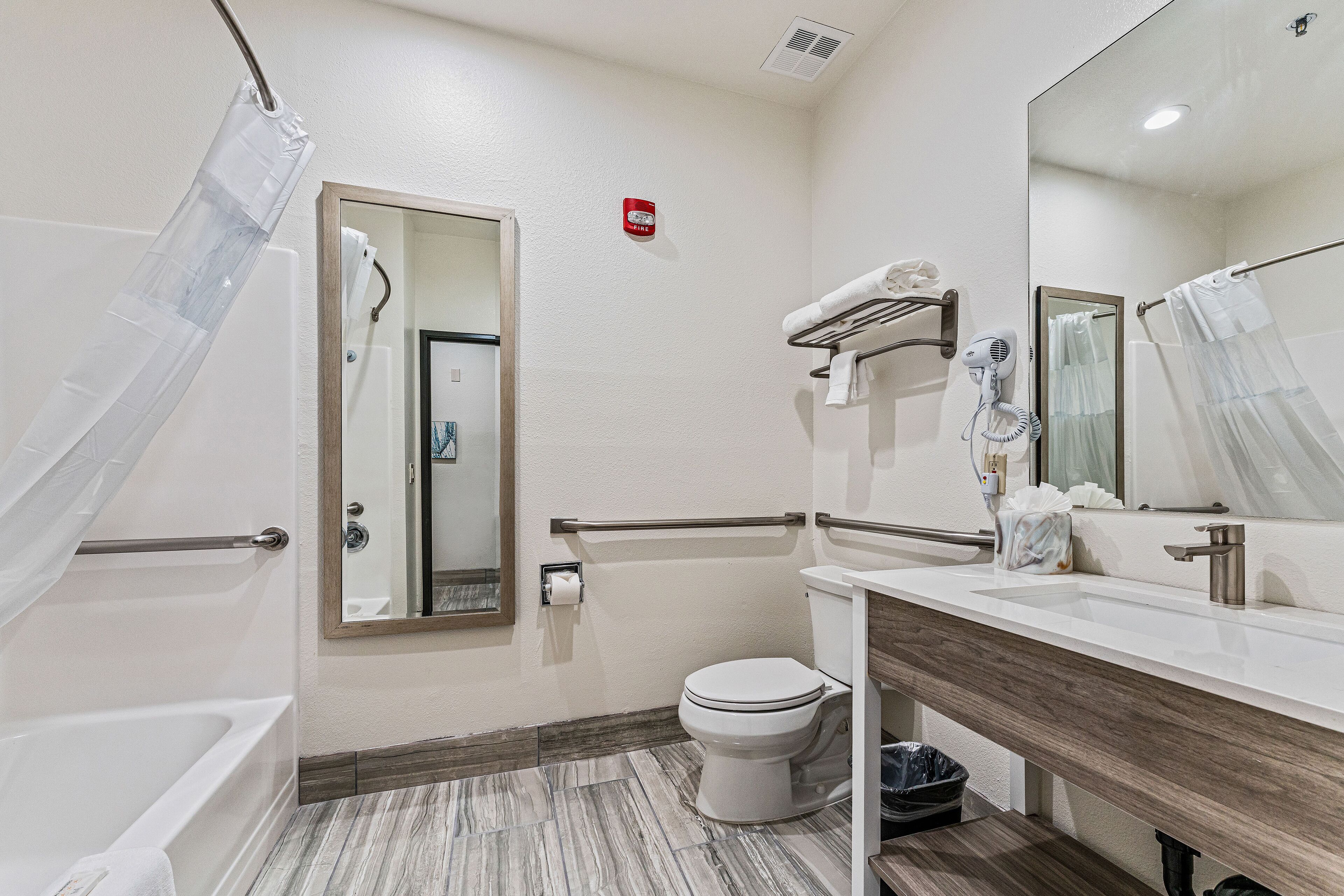 A modern bathroom with a bathtub, toilet, and vanity.
