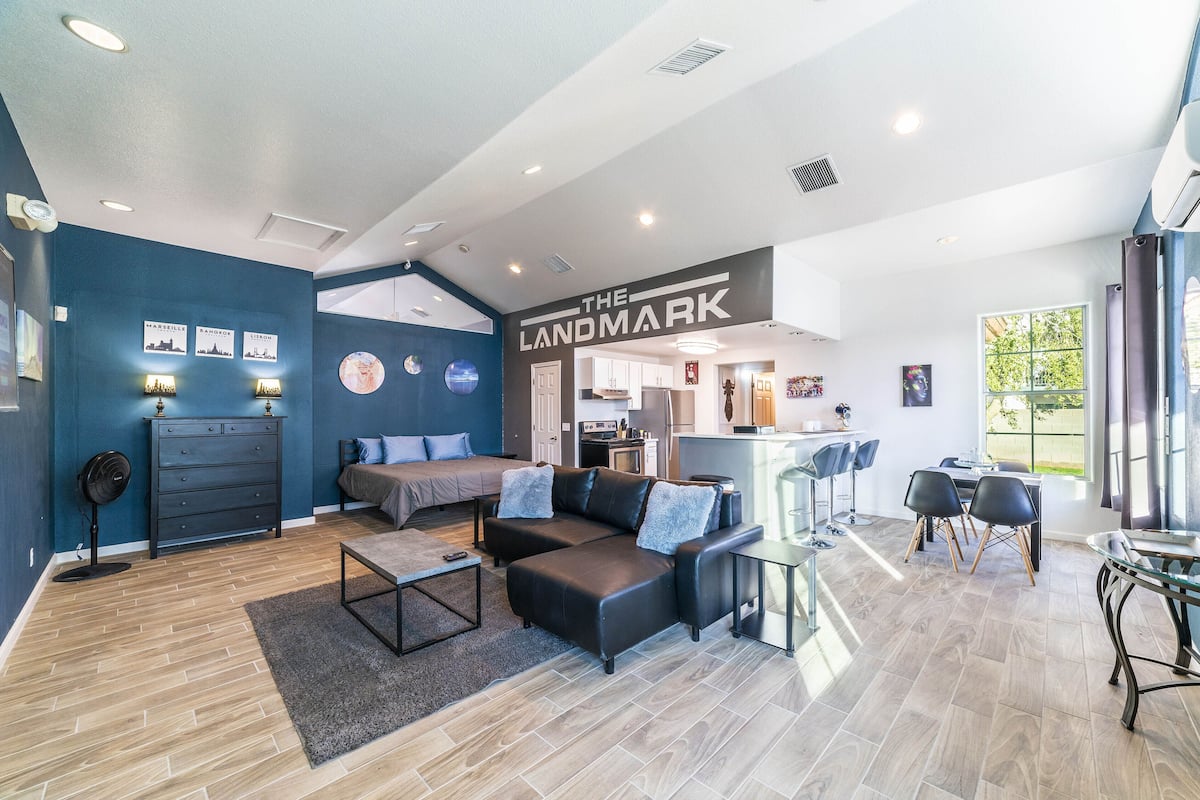 A modern living room with a sectional sofa, a coffee table, and a dining area with a glass table and chairs.