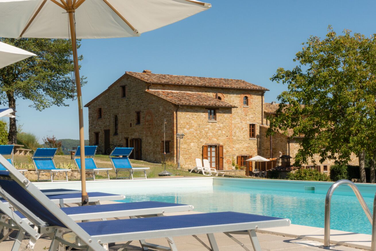 Una piscina al aire libre, sillones reclinables de piscina