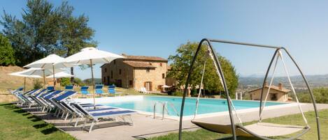 Una piscina al aire libre, tumbonas