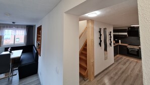A modern apartment with a dining area, a kitchen, and a staircase. - Vacation in nature - view of the Elbe Sandstone Mountains in Saxon Switzerland (Königstein)