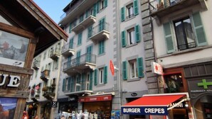 Straßenansicht mit einer Apotheke, einem Burger-Crepes-Laden und einem Souvenirladen.