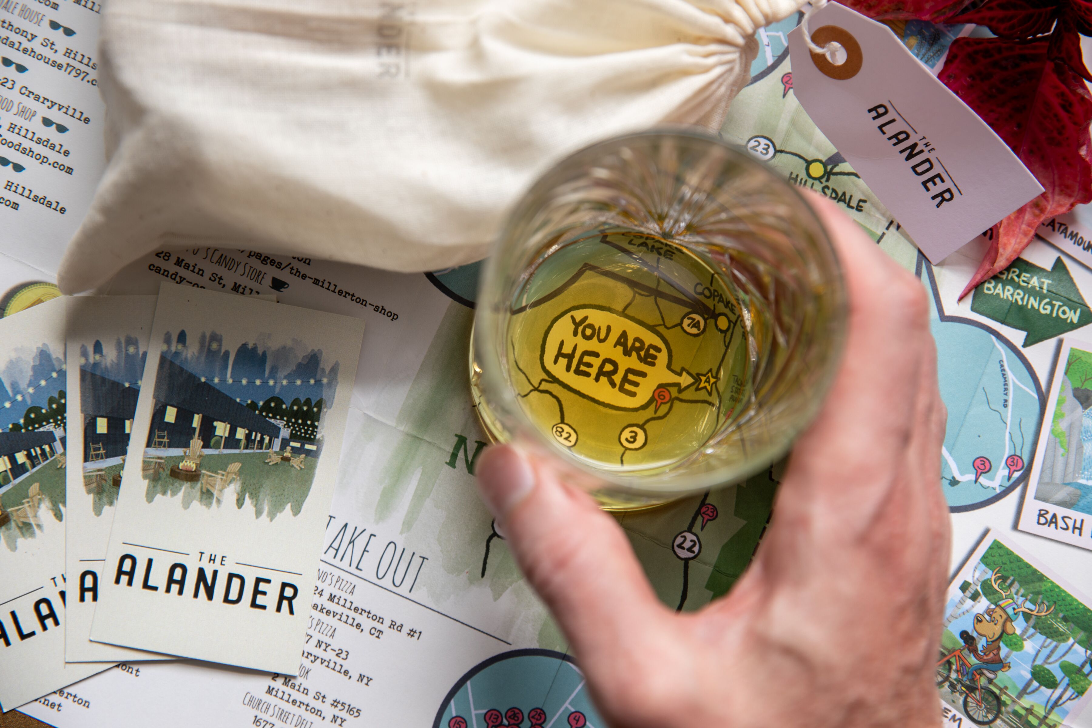 A hand holding a glass with a label that says "You are here".