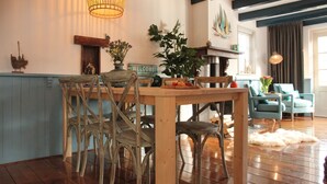 A cozy dining area with a wooden table and chairs, a 'Welcome' sign, and a decorative plant. - Holiday Home in Hindeloopen by Lake (Hindeloopen)
