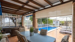 Une terrasse extérieure avec une table, des chaises, une piscine et une vue sur le paysage.