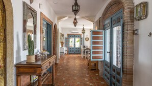 A hallway with a tiled floor, wooden furniture, and blue doors. - Holiday Home 'Finca Arrijana' with Mountain View, Wi-Fi and Air Conditioning (Sayalonga)