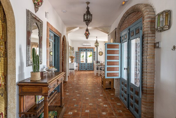 Un pasillo con suelo de baldosas, muebles de madera y puertas azules.