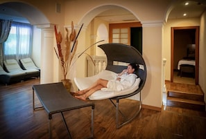 A spa room with a reclining chair, a massage table, and a staircase leading to another area. - Hotel Apartment "Gardasol Romantic 1 Vista Lago" with Lake View, Pool & Wi-Fi (Toscolano maderno)