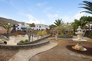 A park with a playground, a fountain, and stone pathways.