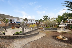 A park with a playground, a fountain, and stone pathways.