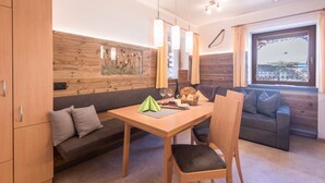 Ein modernes Zimmer mit einem Holzesstisch, einer Couch und einem Fenster mit Blick.