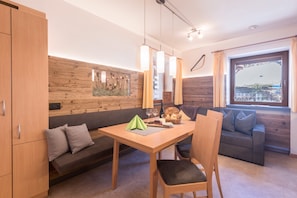 Une chambre moderne avec une table à manger en bois, un canapé et une fenêtre donnant sur un beau paysage.
