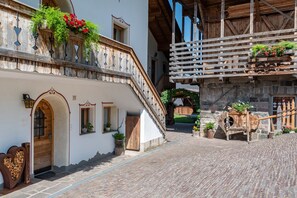 A traditional building with a wooden staircase, a stone wall, and a wooden door.