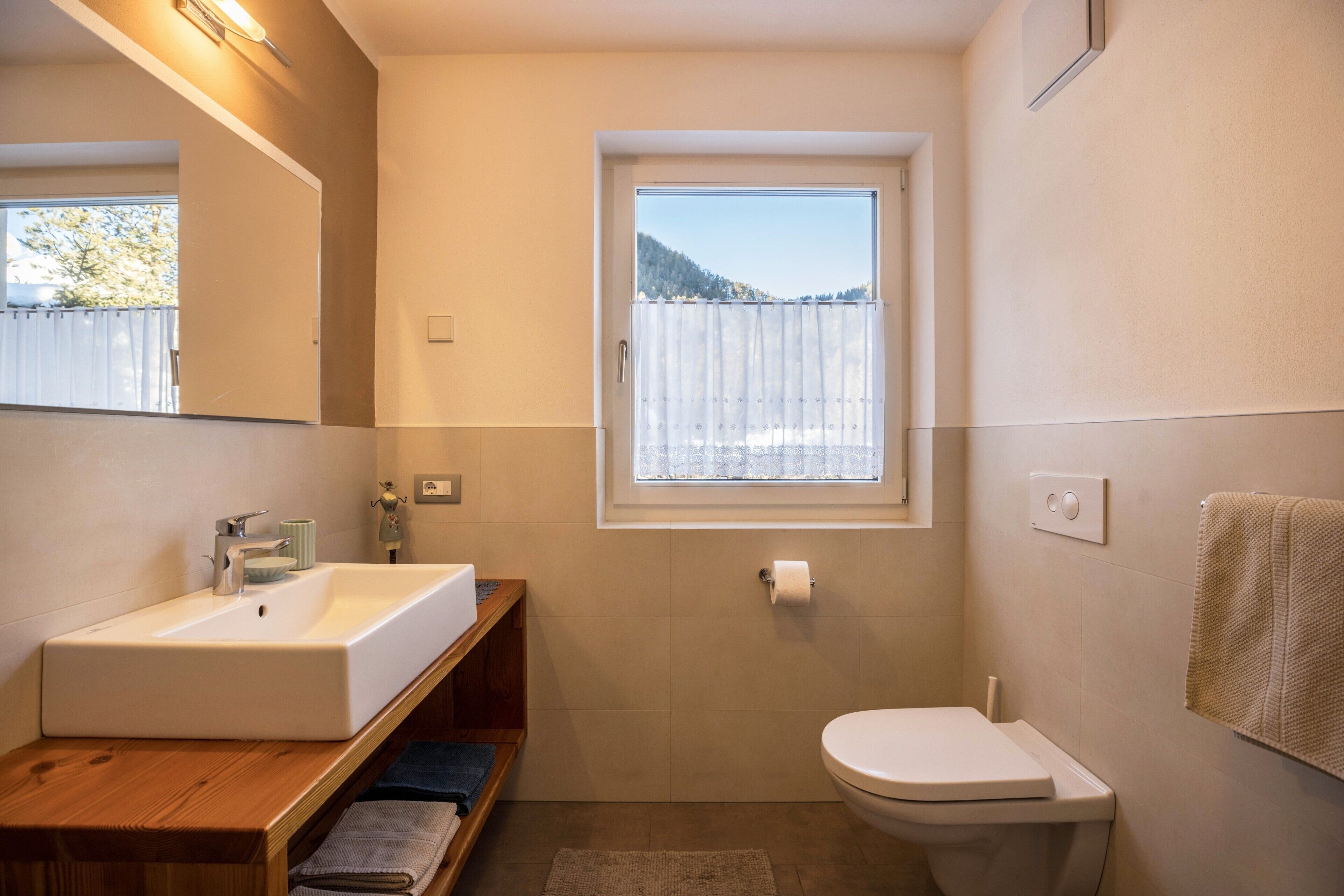 Ein Badezimmer mit Waschbecken, Toilette und Fenster.