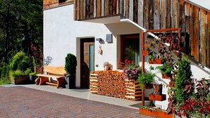 Un bâtiment moderne à l’extérieur en bois, avec un banc et diverses plantes.