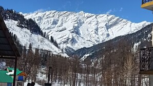 A mountain landscape with snow-covered peaks and a clear blue sky. - Private Room for long and short stay (Manali)
