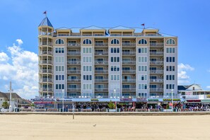 Un hotel de varios pisos con balcones y ubicación frente a la playa.
