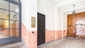 Ein Flur mit einer schwarzen Tür, einer Holztür und einer Treppe, die zu einer oberen Etage führt.