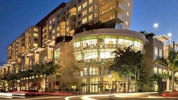 A multi-story hotel with a curved glass facade, surrounded by palm trees and a well-lit street. - Elite 1BD/1BTH in Miami W/FREE PARKING! (Miami)
