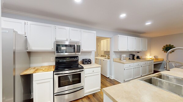 Enjoy cooking in this well-equipped kitchen with a double oven, microwave, toaster, coffee maker, and sink.