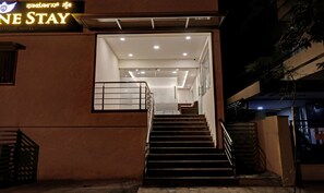 A hotel entrance with a staircase leading to the interior.