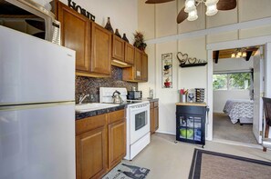 Kitchen area with a bed nearby, offering a view of the outdoors.