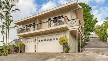 Une maison à deux étages avec un garage, un balcon et une allée.