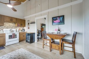 Una cocina con armarios de madera, una estufa y un comedor con mesa y sillas.