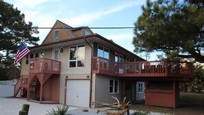 A two-story house with a balcony, a garage, and a small garden area.