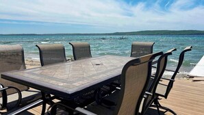 Een tafel en stoelen op een terras met uitzicht op zee en een eiland in de verte.