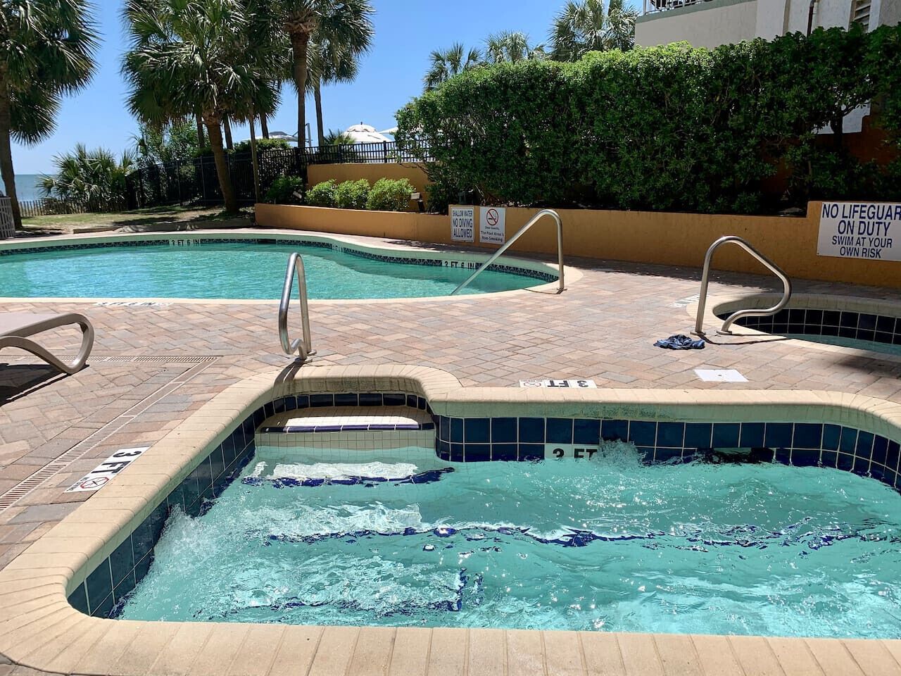 A swimming pool with a tiled edge and a metal ladder.