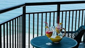 Un balcon avec une table et des chaises donnant sur la mer.
