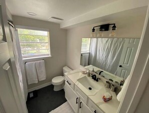 Un baño con inodoro, lavabo y espejo.