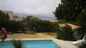 A swimming pool with a view of the sea and mountains in the background. - Villa with land, close to the sea, beach, tennis court... (corbara)