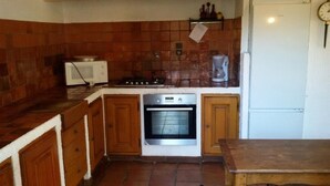 A kitchen with a stove, oven, microwave, and a clock on the wall. - Villa with land, close to the sea, beach, tennis court... (corbara)