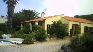 A house with a gravel driveway, a pool, and surrounding greenery. - Villa with land, close to the sea, beach, tennis court... (corbara)