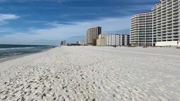 Une plage avec, en arrière-plan, une rangée d’immeubles de grande hauteur.
