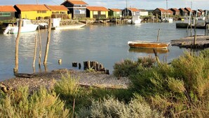 Ett område vid vattnet med förtöjda båtar och hus med röda tak.