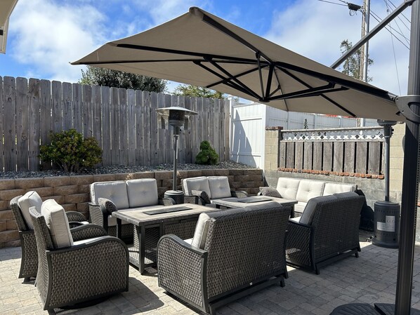Relax in comfort on this patio with wicker furniture and a shaded table.