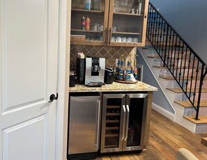 Enjoy a convenient coffee station with a refrigerator, coffee maker, and dispenser.