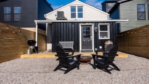 A two-story house with a front porch, a grill, and outdoor seating. - The Rickhouse in NuLu~2 King Bed/2 Full Bath (Louisville)