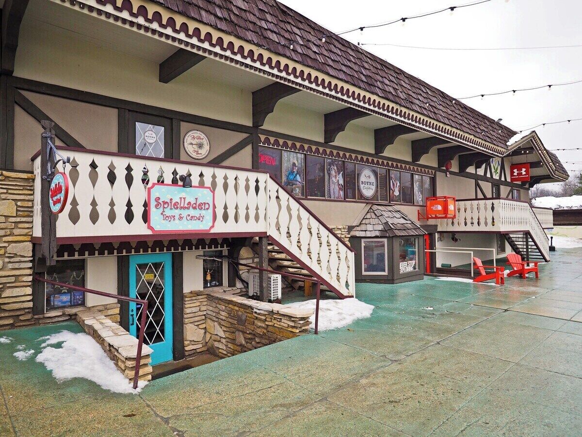 A building with a sign for 'Spielhallen Toys & Candy' and a staircase leading to an upper level.