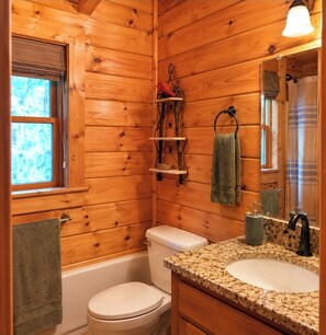 A wooden cabin bathroom with a toilet, sink, and a window. - LUXURY WATWRVIEW CABIN WITH 2 FIREPLACES (Blue Ridge)