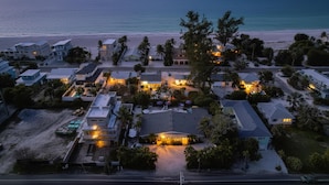 Luchtbeeld van een kustgebied met woonhuizen, een strand en een heldere lucht.