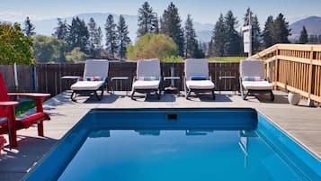 Una piscina al aire libre de temporada, sombrillas